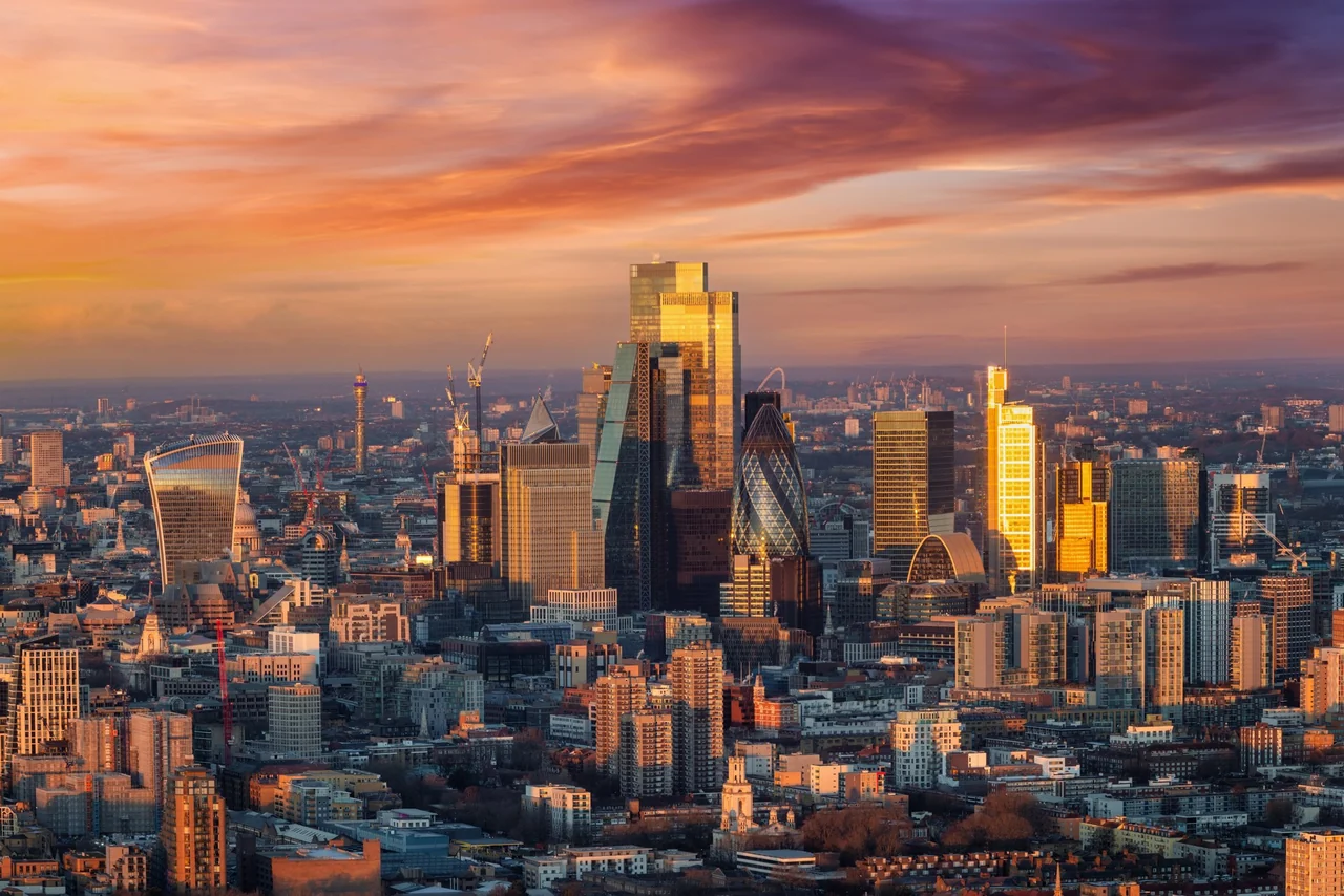 An elevated view across London at sunrise, with the City skyline and St Paul's Cathedral in the foreground