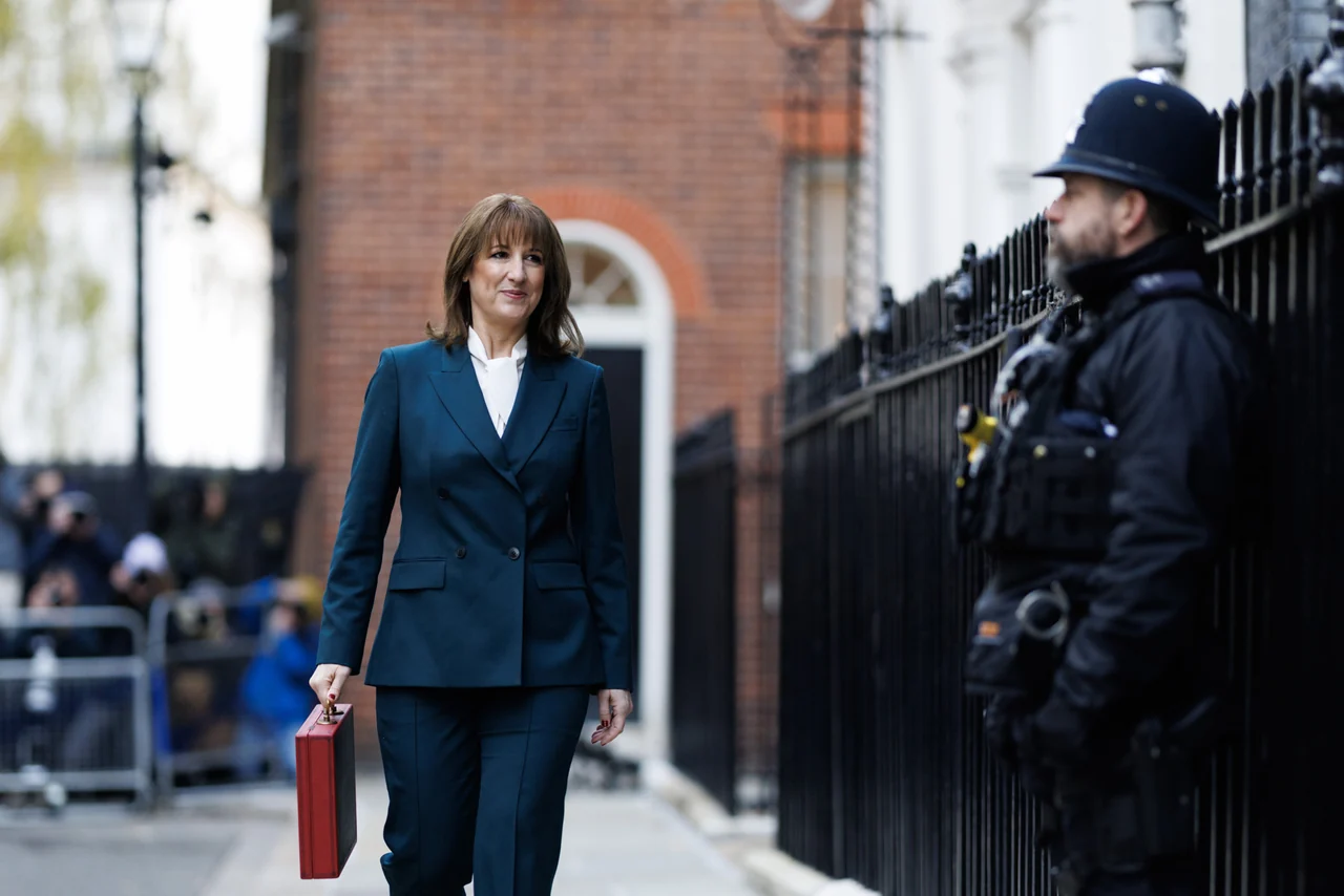 Rachel Reeves walking outside 11 Downing Street carrying the red Budget box, with an officer beside the gate. Archive context from November 2025, not the October 2026 Budget.